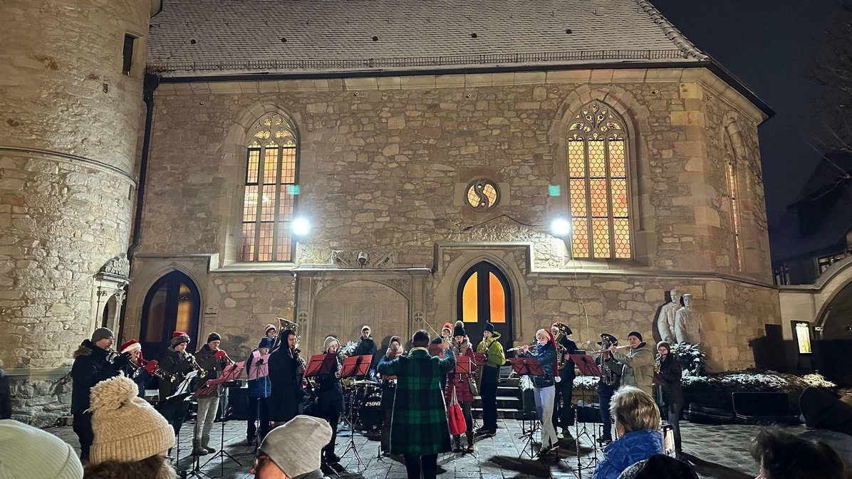 Gruppe von Musizierenden vor einem Kirchengebäude