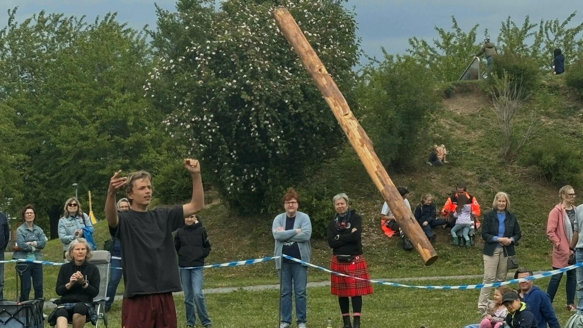Mensch wirft einen Baumstamm